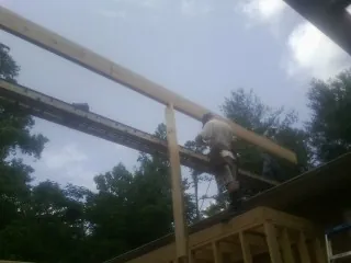 Carpenter setting a ridge beam over a new addition frame — Ice Dam Removal by Roofing Brothers in Sandwich