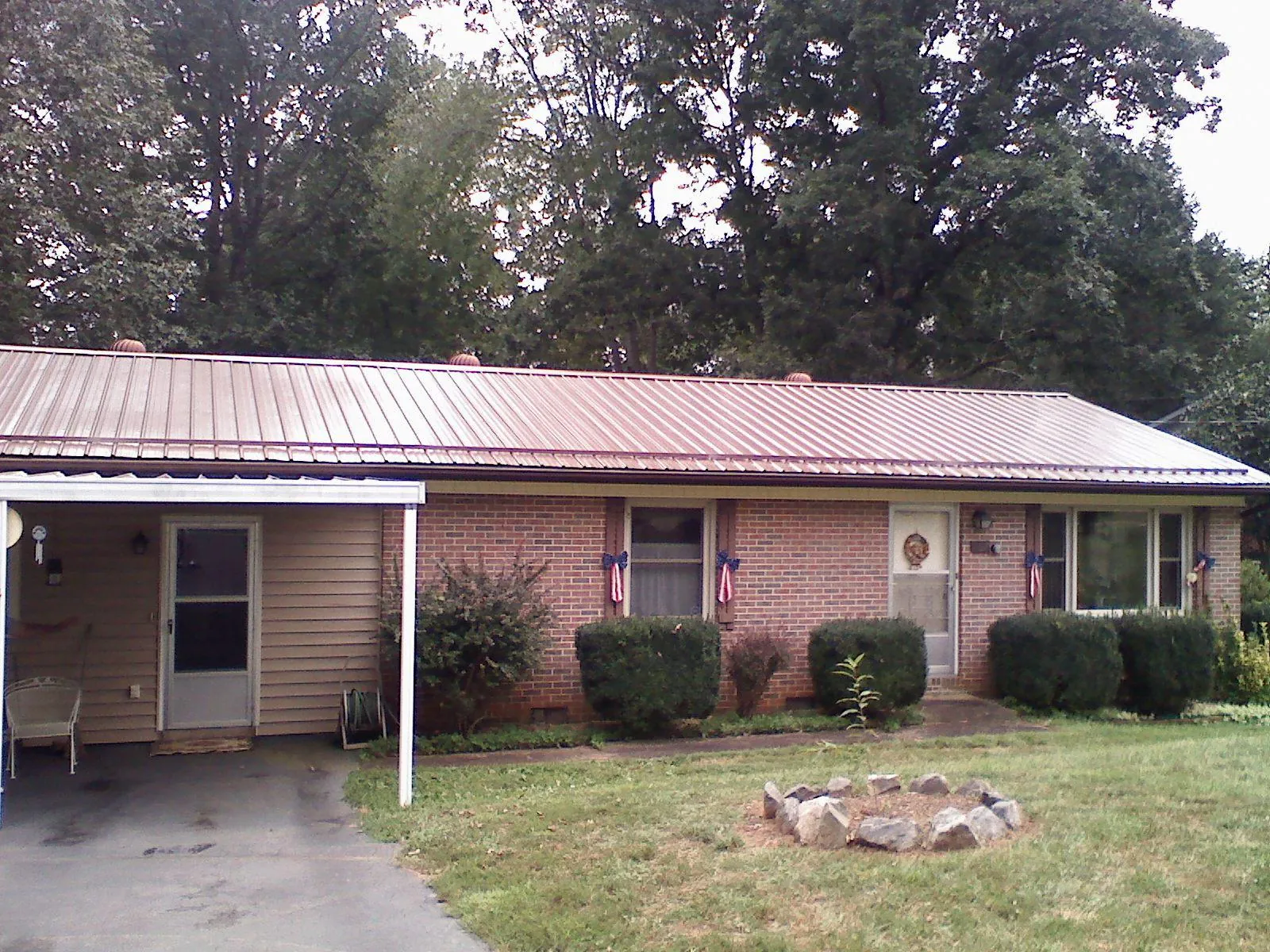 Bronze metal roof and carport on a brick ranch home — Roof Repair work by our crew in Sandwich
